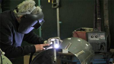 A welder at Eureka's Future factory in Melbourne works on a solar-powered water heater [Jarni Blakkarly/Al Jazeera]